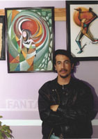 Al-Yemeni with two of his paintings: the left one illustrates that man has succeeded in being set free from the physical chains that shackle his legs, but hes unable to be intellectually free, while the second demonstrates a woman formed of the four seasons.