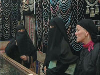In a jewelry shop with a tourist wearing a Yemeni vial.