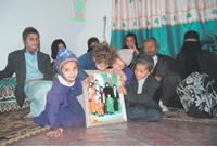 Naharis children gather around a family photo which includes their deceased father one day before the funeral. YT Photo by Amira Al.Sharif