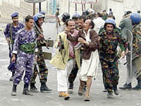One of the protesters taken to the police vehicle to be arrested and interrogated. Photo by Mohamed Al-Qadhi