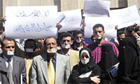 Yemeni journalists show their gagged mouths to symbolize what they think of freedom of the press in Yemen, after the arrest of Saeed Thabet, who was free upon tremendous pressure by the journalist community. (Yemen Times photos by Mohammed al-Qhadi)