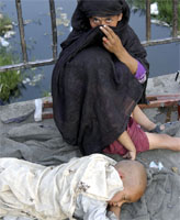 An Afghan mother begging with her two children on the streets of Kabul (Yemen Times photo by Peter Willems)