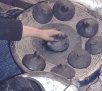 A woman is working with several makhadib at the same time.