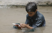 A boy looks at trash that he found in the pond during his swimming. YT PHOTO BY GLYN GOFFIN