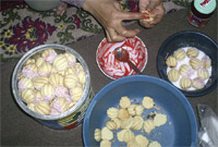 Hands of a woman sticking biscuits with jam.