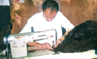 Mohamed Hassan Al-Thawr sewing what once was the skin of a goat to become a lovely leather coat.